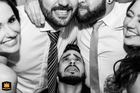 Guests joyfully celebrating at a wedding reception in Villa Santorini, Brazil, captured through nostalgic black and white style.